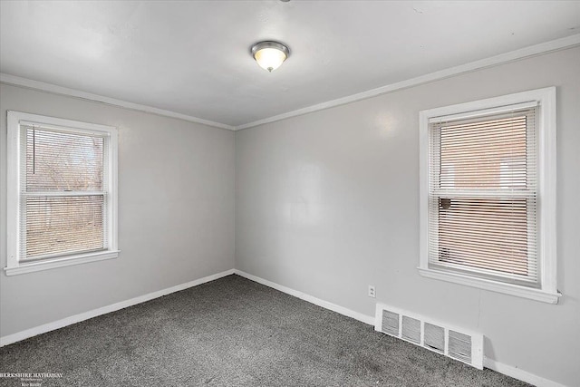 carpeted spare room with crown molding, baseboards, and visible vents