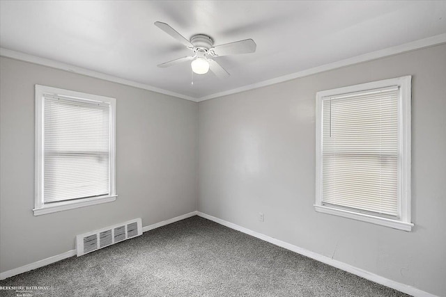 empty room with visible vents, baseboards, ceiling fan, ornamental molding, and carpet floors