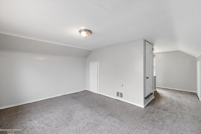 interior space with vaulted ceiling, visible vents, and carpet floors