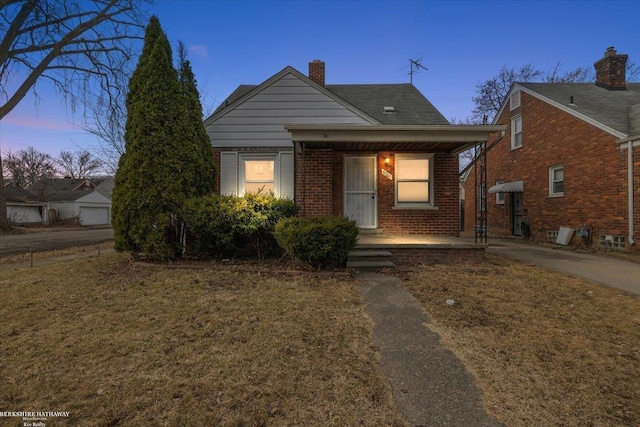 bungalow with brick siding, a porch, and a chimney