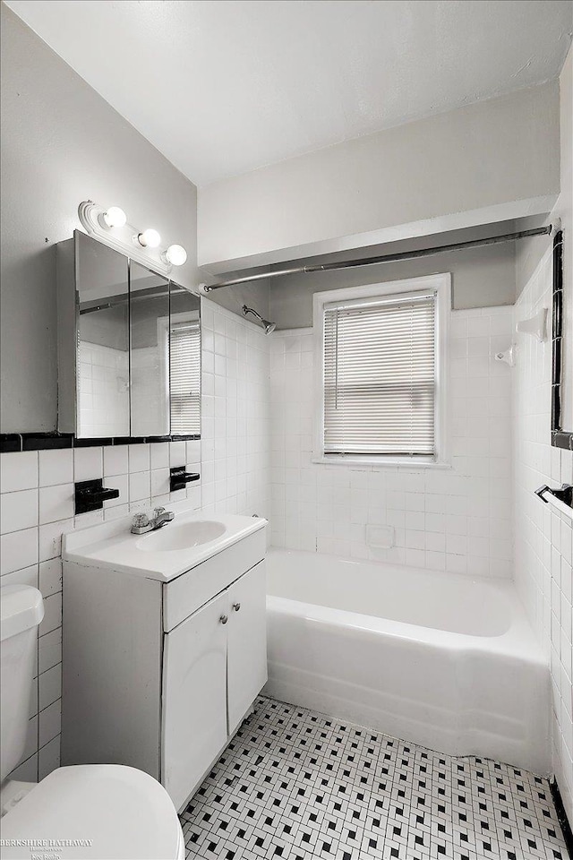 full bathroom featuring vanity, shower / bathing tub combination, tile patterned flooring, tile walls, and toilet