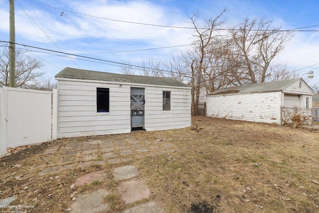 view of outdoor structure featuring an outbuilding and fence