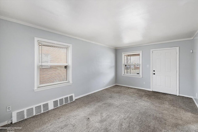 unfurnished room featuring visible vents, carpet floors, baseboards, and crown molding