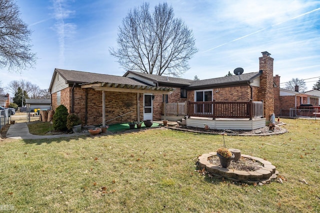 back of property featuring brick siding, a lawn, and fence