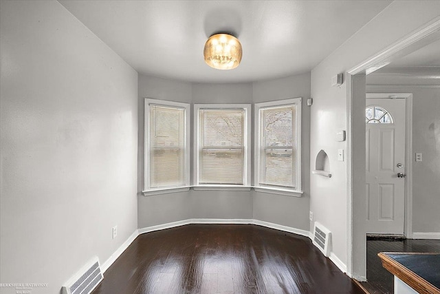 foyer featuring wood finished floors, visible vents, and baseboards