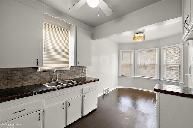 kitchen featuring a ceiling fan, a sink, backsplash, dark wood finished floors, and white cabinets