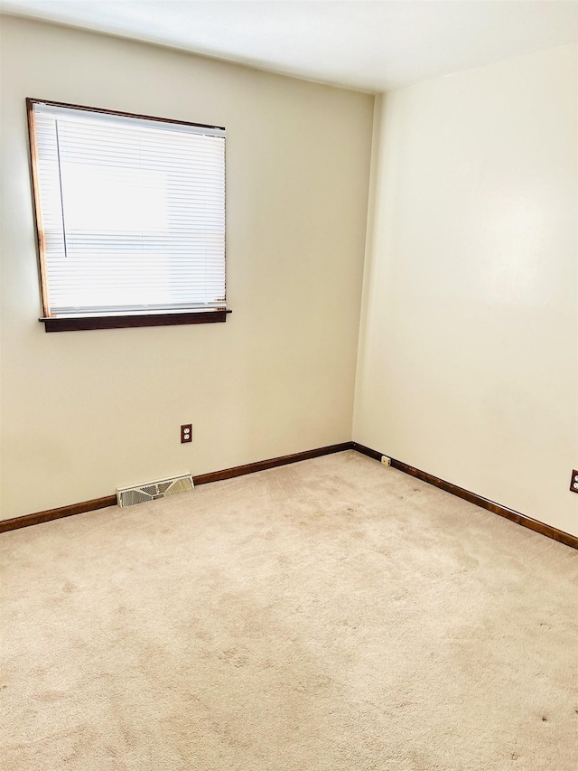 carpeted empty room with visible vents and baseboards