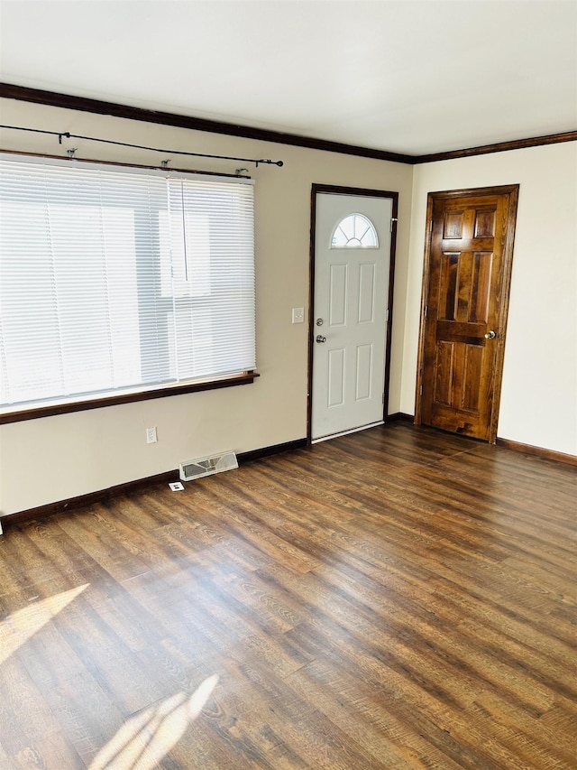 foyer with visible vents, baseboards, ornamental molding, and dark wood-style flooring