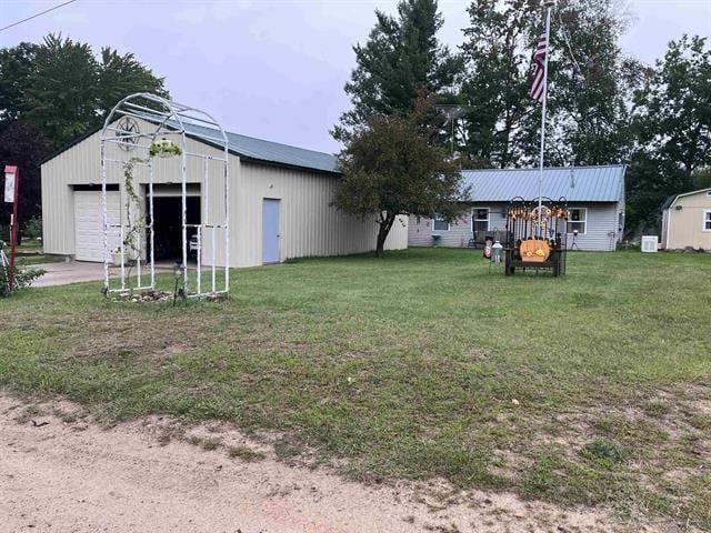 view of yard with an outbuilding, a garage, and a pole building