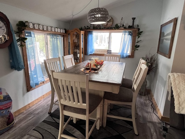 dining area with vaulted ceiling, baseboards, and wood finished floors