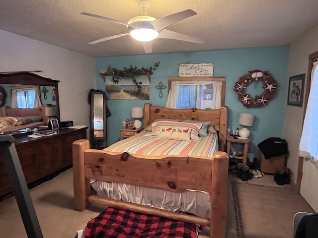 bedroom with carpet flooring, a ceiling fan, and a textured ceiling