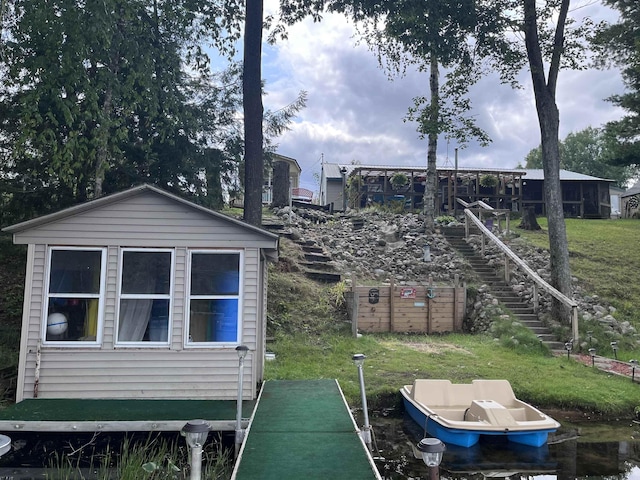 rear view of property with an outbuilding and stairs