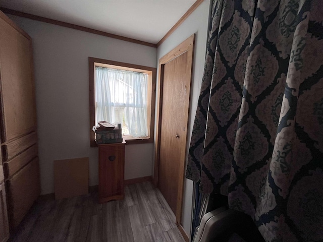 interior space featuring light wood-type flooring, baseboards, and ornamental molding