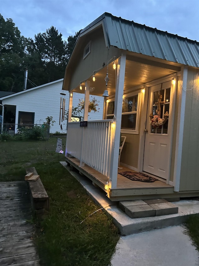 exterior space with metal roof and a yard