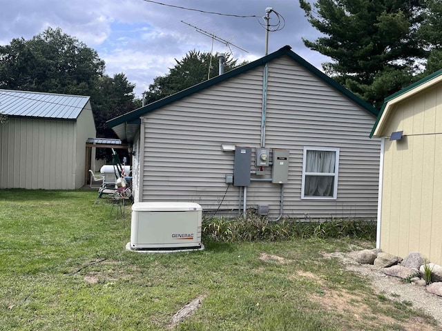 view of home's exterior featuring a lawn, a storage unit, and an outdoor structure