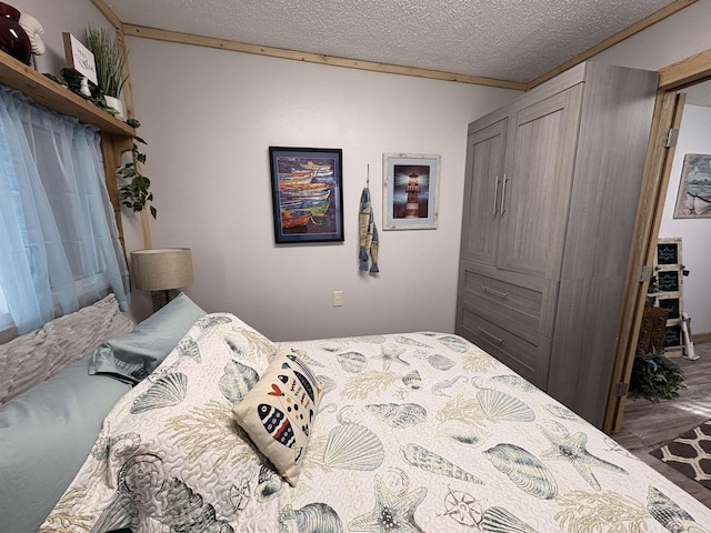 bedroom featuring a closet, a textured ceiling, and wood finished floors