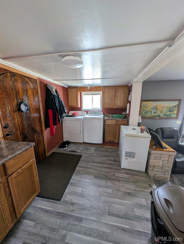 kitchen featuring fridge, brown cabinets, separate washer and dryer, and light wood finished floors