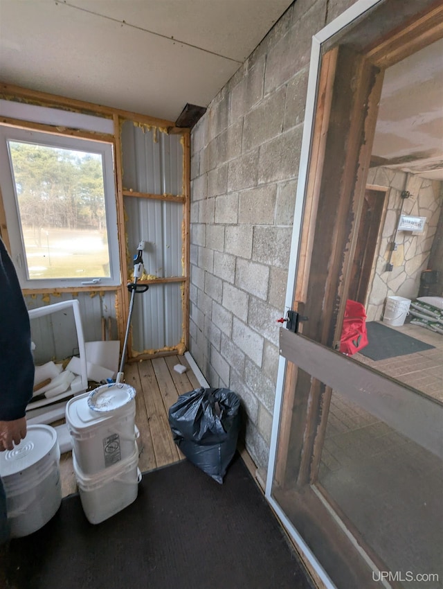 misc room featuring concrete block wall and hardwood / wood-style flooring