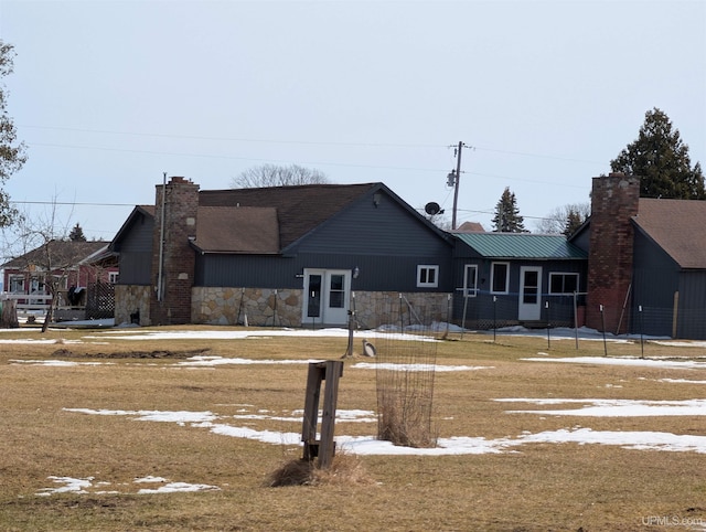 view of front facade with stone siding and a chimney