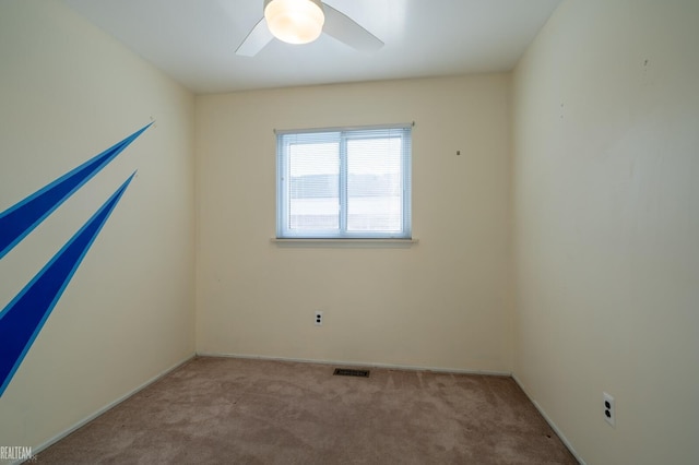 carpeted empty room featuring visible vents and ceiling fan