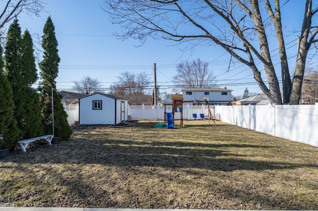 view of yard with an outbuilding, a storage shed, a playground, and a fenced backyard