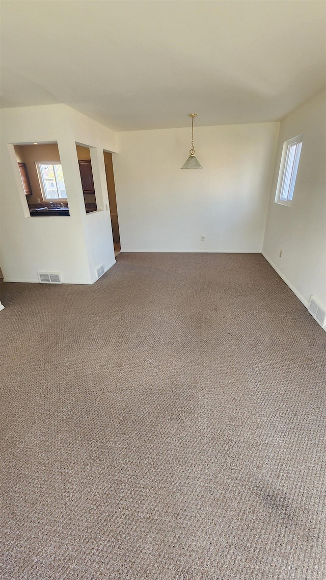 carpeted spare room featuring visible vents