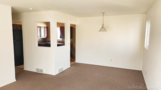 empty room with visible vents, baseboards, and carpet floors