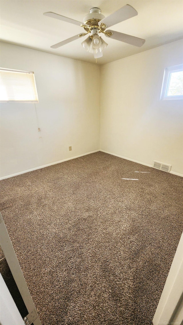 spare room featuring carpet, visible vents, and ceiling fan