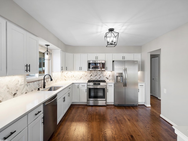 kitchen featuring a sink, stainless steel appliances, light countertops, white cabinets, and tasteful backsplash