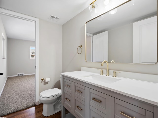 bathroom featuring visible vents, toilet, vanity, and baseboards