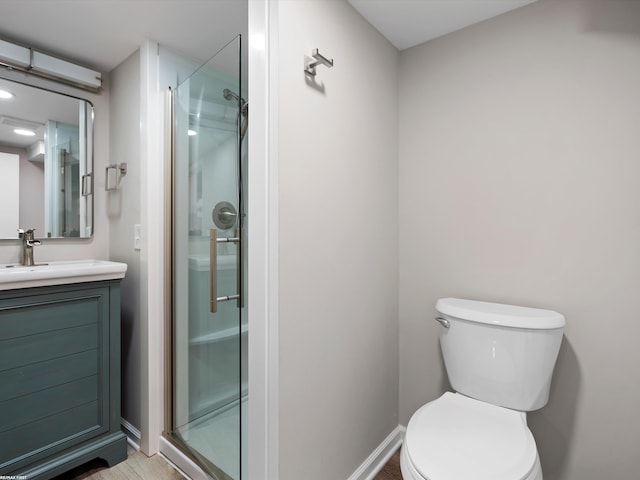 full bathroom with vanity, toilet, baseboards, and a stall shower