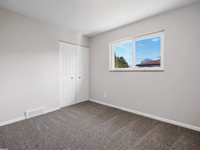 unfurnished bedroom with visible vents, baseboards, a closet, and carpet flooring