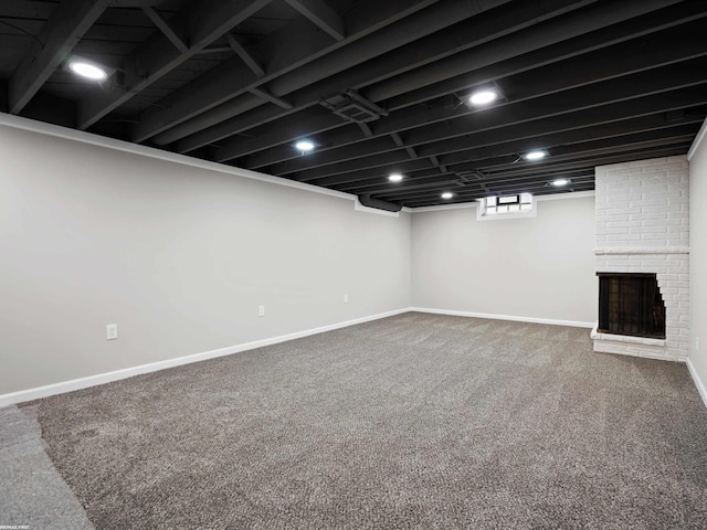 basement with baseboards, carpet, and a brick fireplace