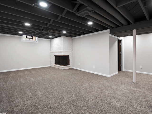 below grade area with a brick fireplace, baseboards, and carpet floors