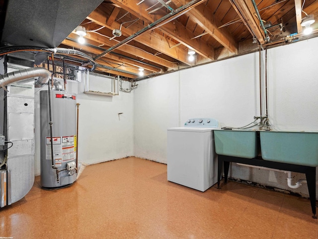 unfinished basement featuring gas water heater, washer / dryer, tile patterned floors, and a sink