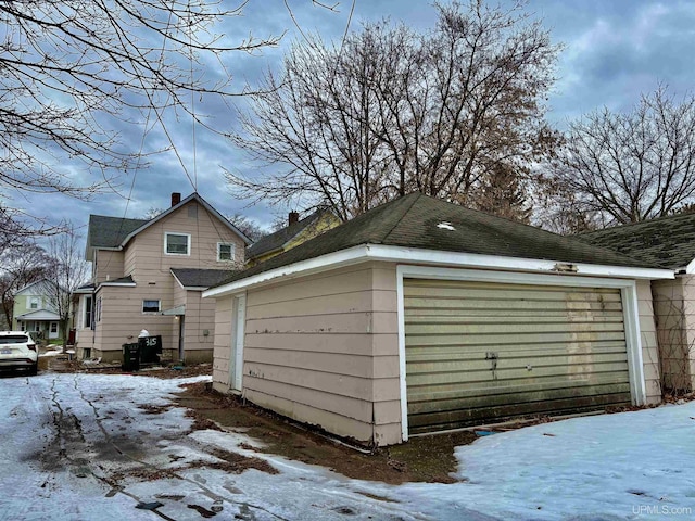 snow covered garage featuring a garage