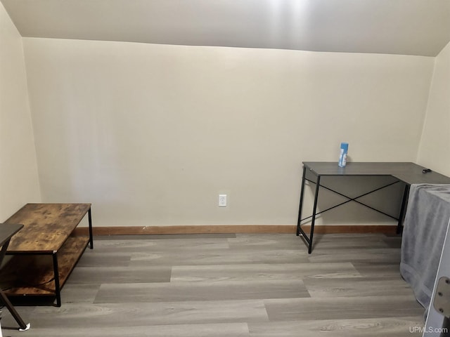 interior space featuring baseboards and wood finished floors