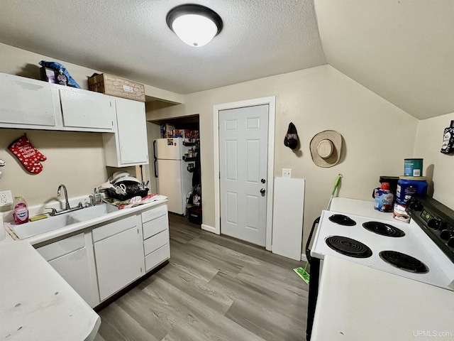 kitchen featuring white appliances, white cabinets, light wood-type flooring, and a sink