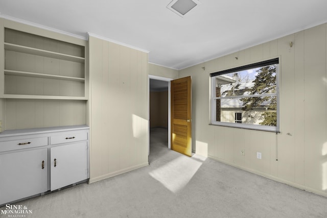 unfurnished bedroom featuring ornamental molding, baseboards, and light carpet