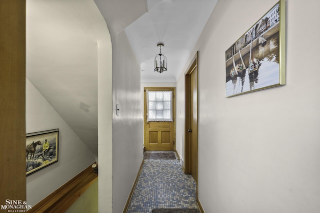 corridor featuring baseboards and arched walkways