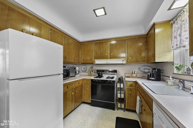 kitchen featuring under cabinet range hood, white appliances, light countertops, and a sink