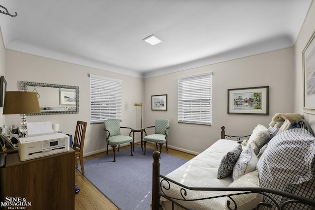 bedroom with light wood-type flooring and baseboards