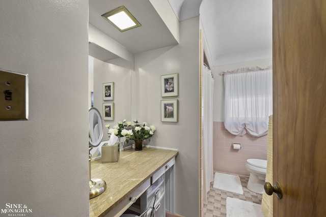 full bathroom with vanity, tile walls, toilet, and a shower with shower curtain