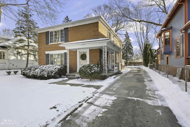 view of front facade with brick siding and a porch