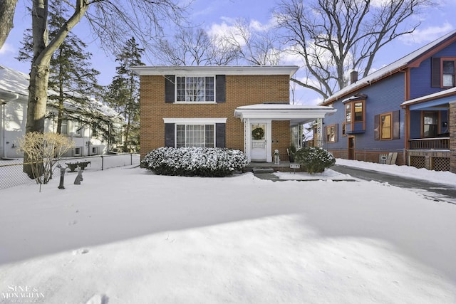 view of front of property with brick siding and fence