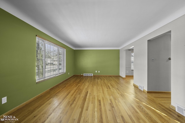 unfurnished living room with visible vents and light wood-style floors