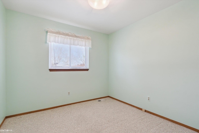 empty room featuring baseboards and carpet floors