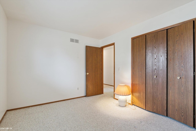 unfurnished bedroom with visible vents, baseboards, a closet, and carpet flooring