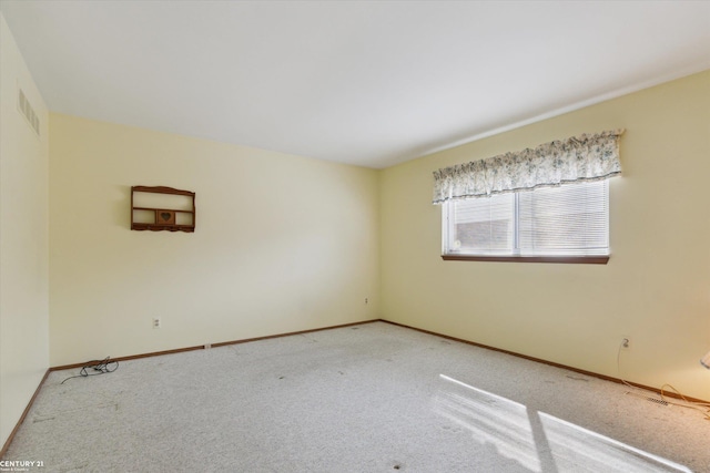 unfurnished room featuring light colored carpet, visible vents, and baseboards