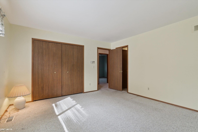 unfurnished bedroom featuring a closet, visible vents, light carpet, and baseboards